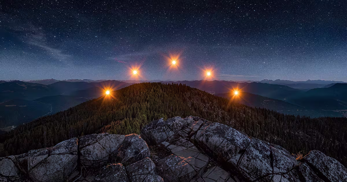 Glowing orbs hang over a dark ridge, seen from a rocky overlook. Illustration.