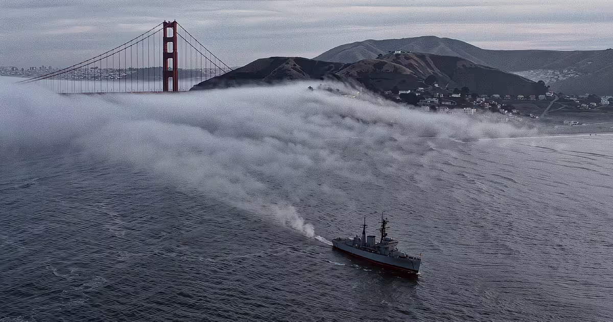 A grey Navy ship trailing mist in the fog below the Golden Gate Bridge. Illustration.